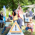 Mehrere Personen auf einer Wiese, eine Person nimmt an einem Experiment teil