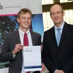 Auf dem Bild steht Oskar Wernitz neben Prof. Dr. Sonnentag und hält stolz seine Auszeichnung in die Kamera. Im Juni 2024 wurde der Absolvent feierlich mit dem Wolf-Rüdiger-Bub-Preis geehrt.