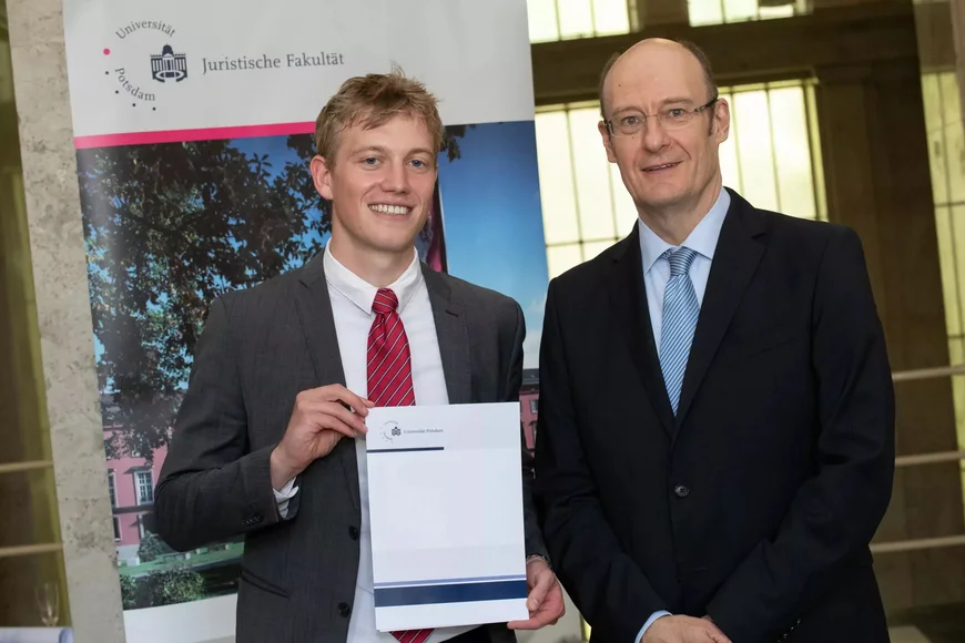 Auf dem Bild steht Oskar Wernitz neben Prof. Dr. Sonnentag und hält stolz seine Auszeichnung in die Kamera. Im Juni 2024 wurde der Absolvent feierlich mit dem Wolf-Rüdiger-Bub-Preis geehrt.