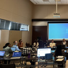 NamTip researchers sitting in a chair in a conference room and engaging in a discussion