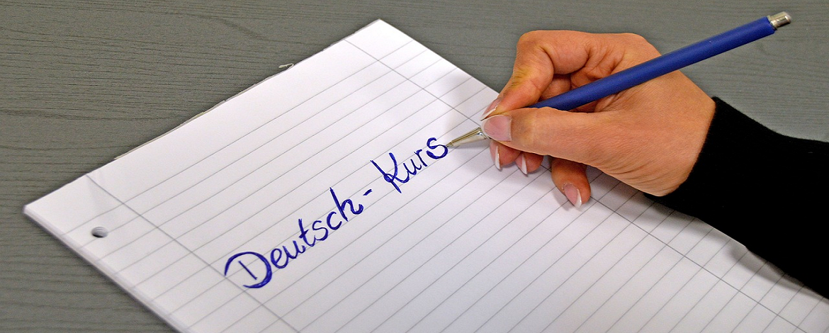 hand writing "Deutsch-Kurs" on a piece of paper - 