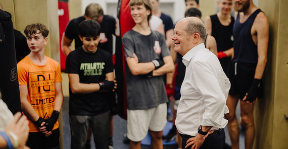 Bundeskanzler Olaf Scholz im Gespräch mit Jugendlichen des Projekts FAIR im Kampfsportraum der Uni Potsdam.