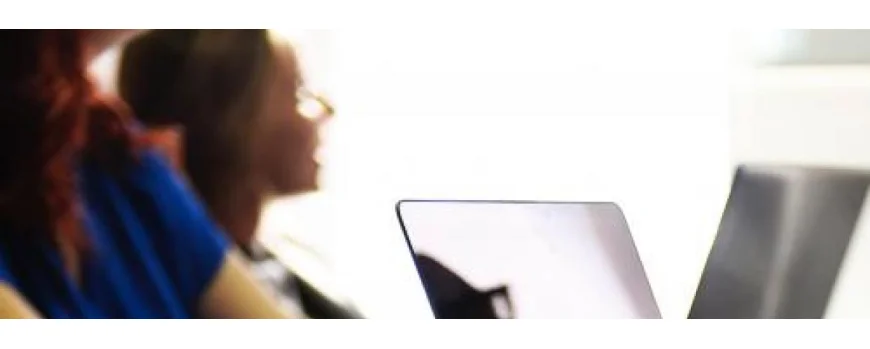Zwei Personen, die vor Laptops sitzen.