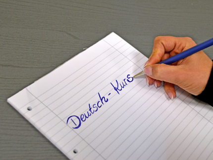 hand writing "Deutsch-Kurs" on a paper