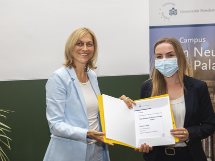 Die Studiendekanin überreicht der Preisträgerin Juliane Clegg die Urkunde für den Lehrpreis 2022.
