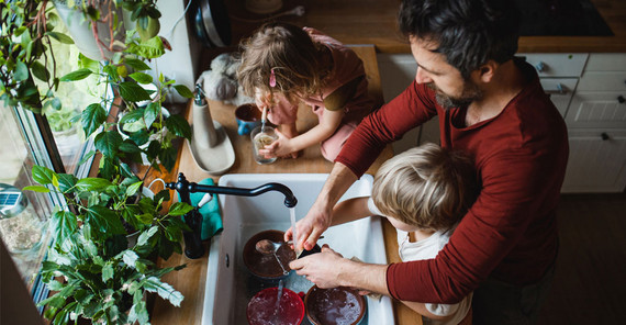 Man with two children in the kitchen.