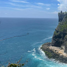 Hinduistischer Tempel in Uluwatu an den Klippen der Halbinsel. Die Klippen sind stark bewachsen und befinden sich direkt am Meer.