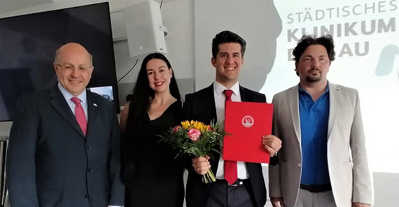 Drei Männer und eine Frau auf einem Gratulationsfoto