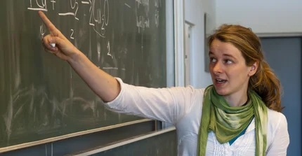 Teacher points to blackboard