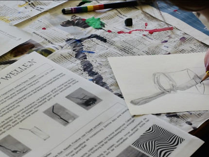 Jemand zeichnet einen Pinsel im Wasserglas.