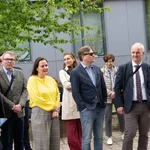 Mehrere Personen stehen vor einem Gebäude.