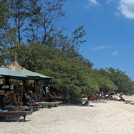 Menschen an einem tropischen Strand mit Meer und Palmen
