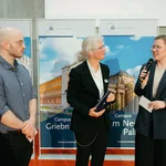 Drei Personen im Gespräch auf einem Podium