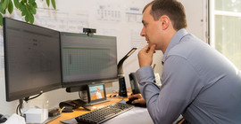 Christian Stempfl sitzt an seinem Arbeitsplatz und schaut auf den PC-Monitor.