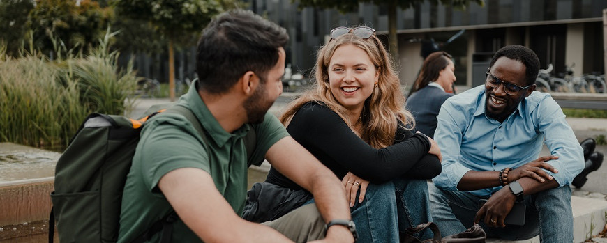 three students talking and laughing