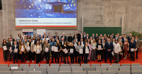 Gruppe von Menschen, die in einem Hörsaal fürs Foto zusammensteht