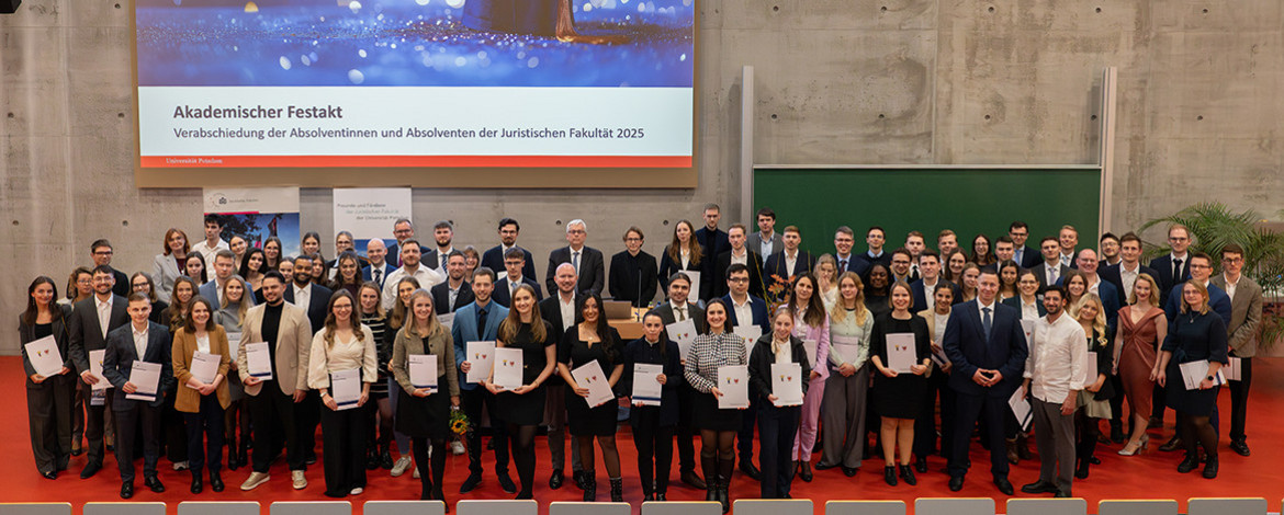 Gruppe von Menschen, die in einem Hörsaal fürs Foto zusammensteht - 