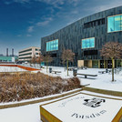 Das IKMZ in Golm im Winter bei Schnee und ein zugeschneites Uni-Logo auf dem Platz davor.