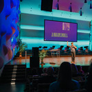 Student Bryan Nowack macht auf der Bühne einen Science Slam, veranschaulicht durch eine PowerPoint Präsentation.