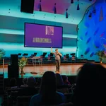 Student Bryan Nowack macht auf der Bühne einen Science Slam, veranschaulicht durch eine PowerPoint Präsentation.