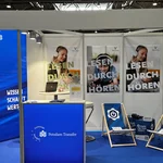 Messestand mit blauen Messewänden und Logo Universität Potsdam und Strandstühle als Sitzgelegenheit