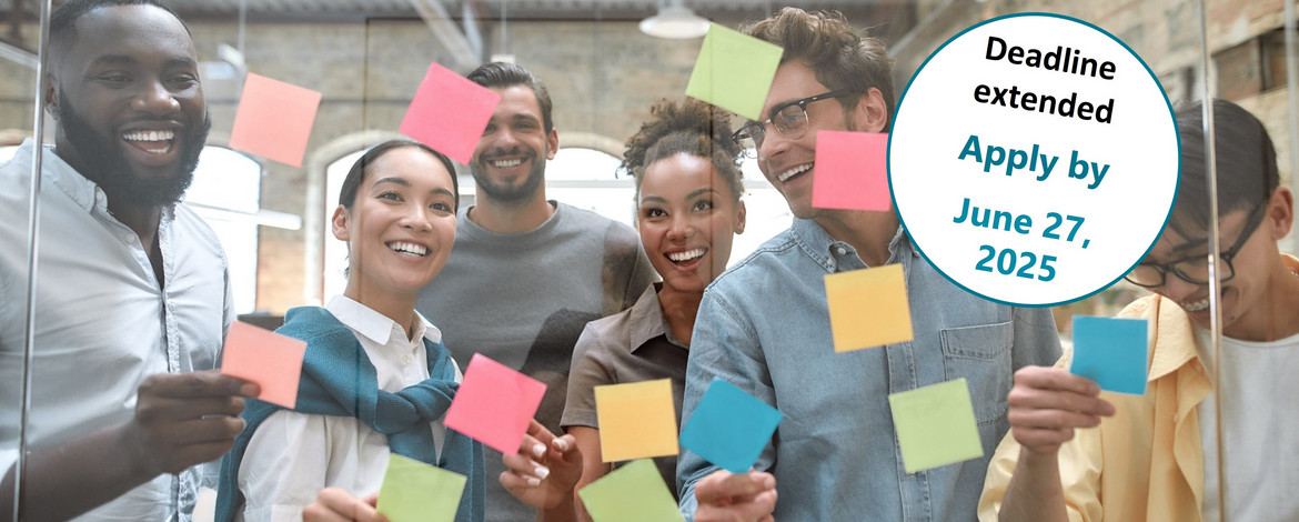 Verschiedene, junge Menschen stehen vor einer Glaswand, die mit bunten Klebezetteln beklebt ist. - PhD Peer Support Program