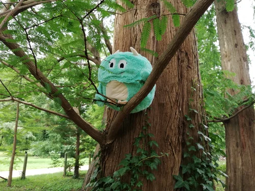 Kleiner grüner Kobold in einer Astgabel