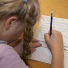 Ein Mädchen schreibt etwas in ihr Notizheft.
