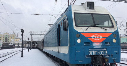 Ein langer blauer Zug in einer Schneelandschaft