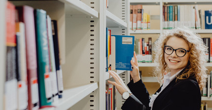 Studentin am Bücherregal