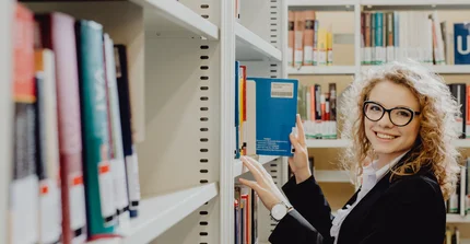 Studentin am Bücherregal