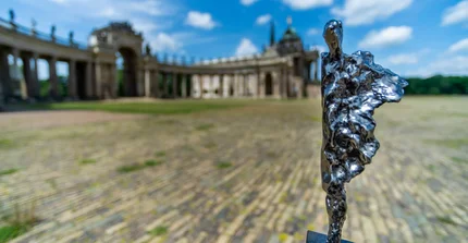 Die Voltaire-Preis-Statue steht auf dem Mopke vor dem Kolonnadenbogen