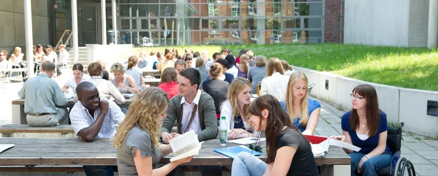 A group of students is sitting around a table at the mensa in Griebnitzsee. Photo: Karla Fritze