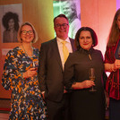 Fünf Personen mit Getränken in der Hand lächeln in die Kamera.