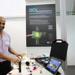 Prof. Banerji zeigt an einem Messestand seinen Expermentierkoffer