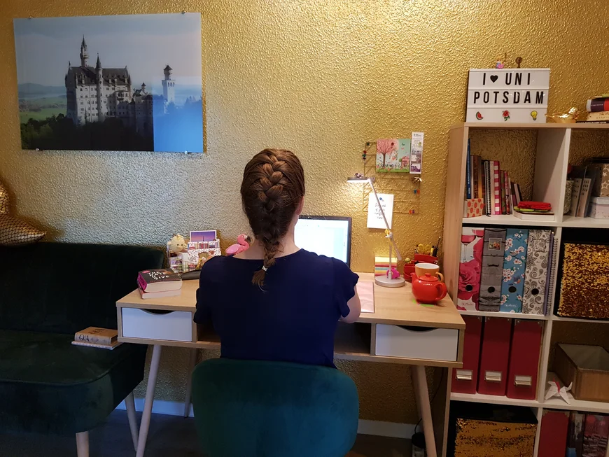 Mensch vor Schreibtisch vor golderner Wand