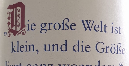 Im Hintergrund ein Gebäude, davor eine Wiese