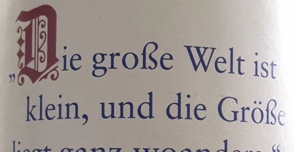 Im Hintergrund ein Gebäude, davor eine Wiese