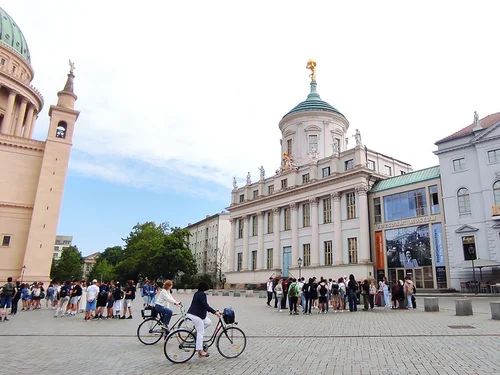 Platz mit historischen Gebäuden und Menschengruppen