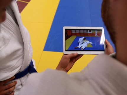 Zwei Judoka schauen auf einen Tablet-PC