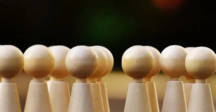Spielfiguren vor einem dunkelen Hintergrund.