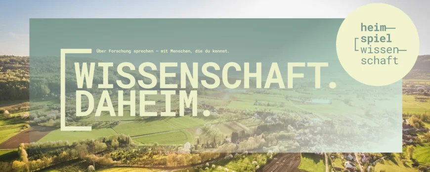 Eine Luftaufnahme von Wiesen und Feldern und einem Dorf