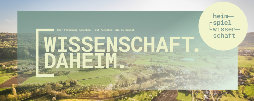 Eine Luftaufnahme von Wiesen und Feldern und einem Dorf