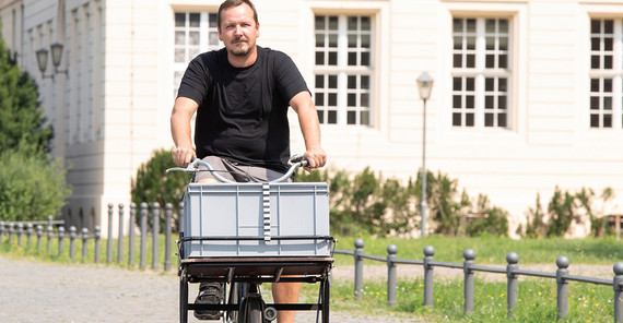 Hausmeister Tilo Peltzer ist mit dem Rad auf dem Campus unterwegs.