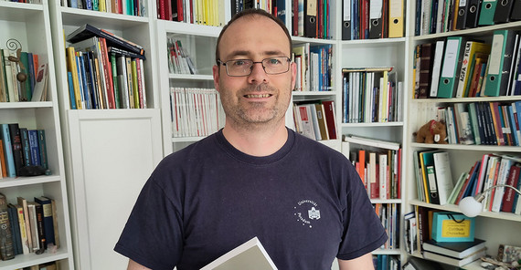 Portrait von Měto-Nowak vor Bücherwand