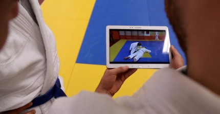 Zwei Judoka schauen auf ein Tablet