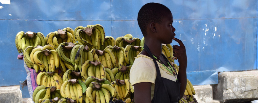 A young woman sells bananas.