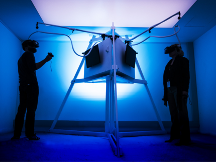 zwei Menschen mit VR-Brille im blau beleuchteten VR-Raum
