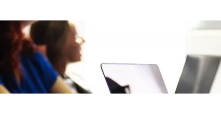 Zwei Personen, die vor Laptops sitzen.