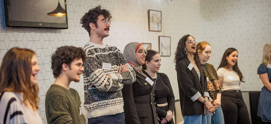 Internationale EDUC Studierende, die in einem Raum zusammen stehen und fröhlich lachen